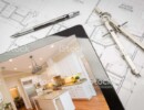 Computer Tablet Showing Finished Kitchen Sitting On House Plans With Pencil and Compass.